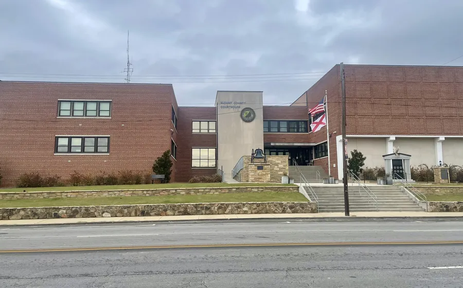 Brick county courthouse building with a flag in front