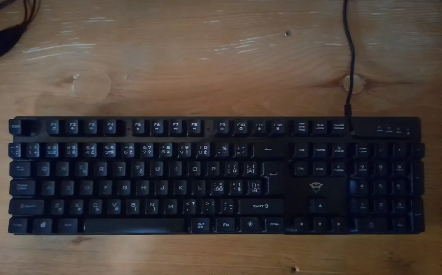 Black computer keyboard on a dark wooden desk