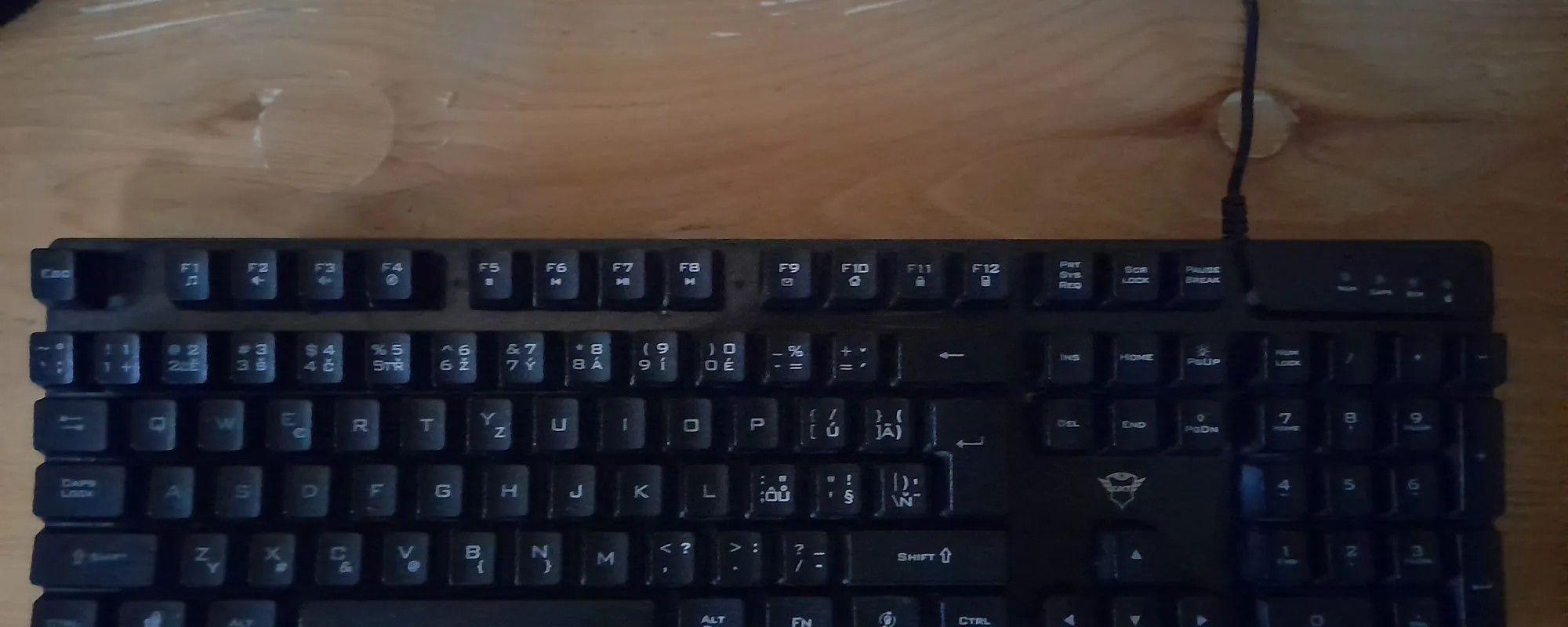 Black computer keyboard on a dark wooden desk