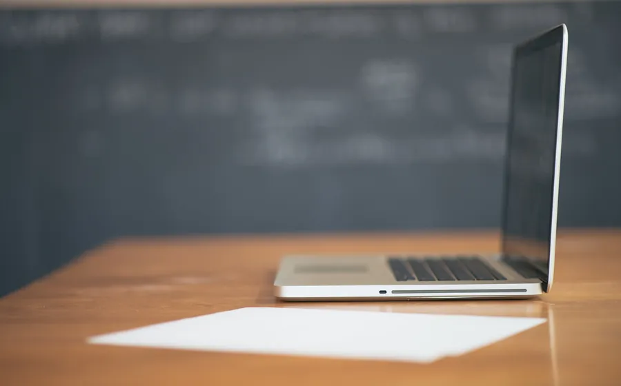 Laptop open on a clean wooden desk in a bright office
