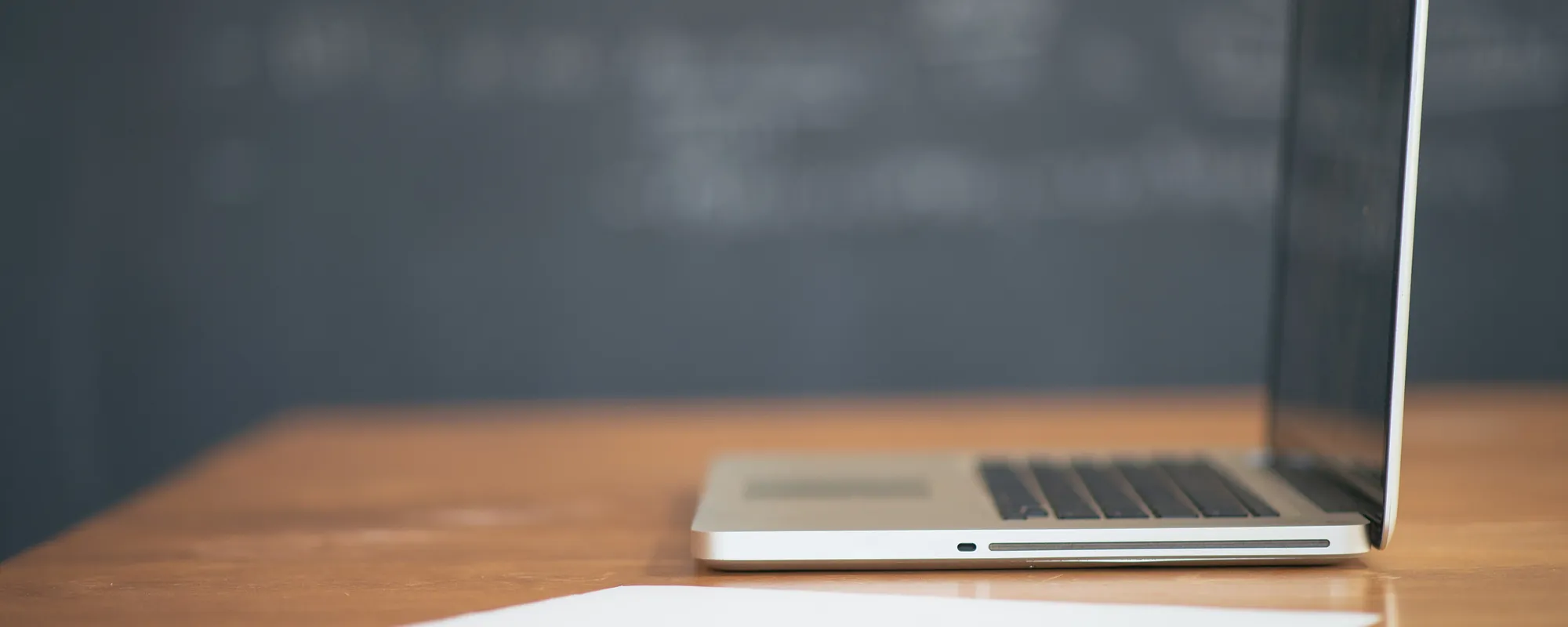 Laptop open on a clean wooden desk in a bright office
