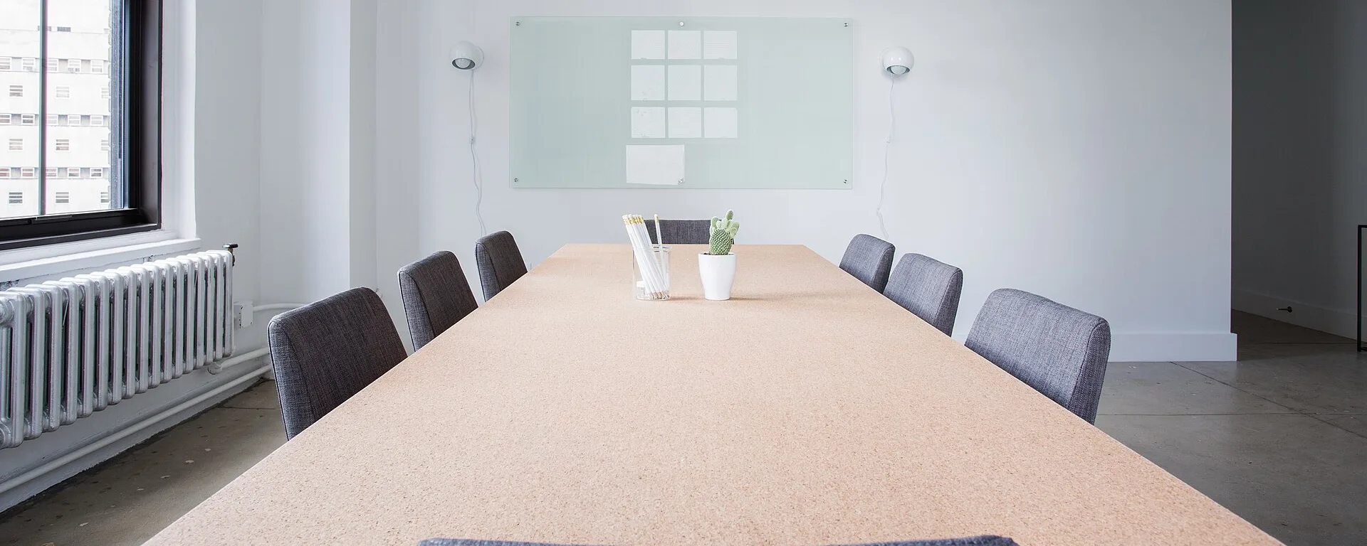 Empty conference room with a long table, chairs, and a whiteboard